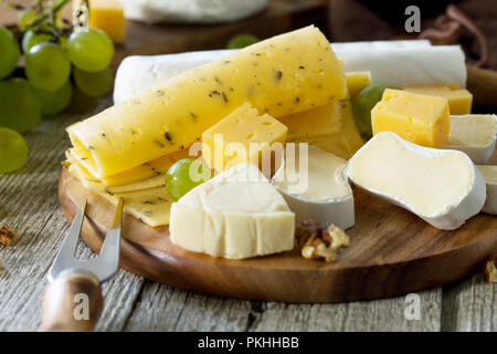 Verschiedene Käsesorten auf rustikalen Holztisch. Stockfoto