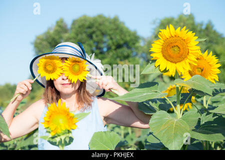 Ein Porträt von Frau mittleren Alters Sonnenblumen als Symbole Stockfoto