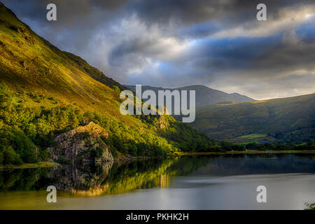 Die Sonne erstmals nach einer Nacht der Regen, glänzend auf Gallt Y Wenallt neben Llyn Gwynant in Snowdonia (Eryri), Wales (Cymru Stockfoto