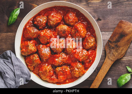Leckeres Rindfleisch braten Frikadellen in Tomatensoße in einer Weißen Wanne auf einem Küchentisch. Essen Fotografie, Ansicht von oben, Schweden traditionelle Küche. Stockfoto