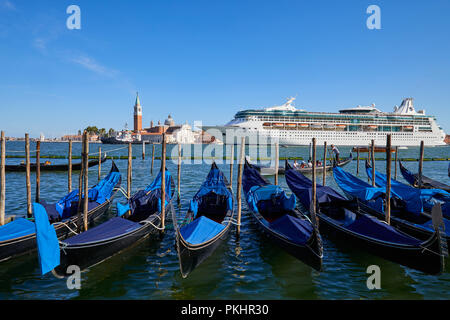 Venedig, Italien, 12. AUGUST 2017: Große weiße Kreuzfahrtschiff vorbei an der Gondeln und San Giorgio Maggiore Basilika in Venedig am Morgen, blauer Himmel in einem Stockfoto