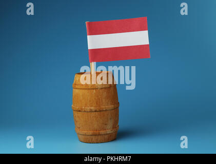 Ein Papier Nationalflagge von Österreich auf Holzstab im Holzfass blauer Hintergrund Stockfoto