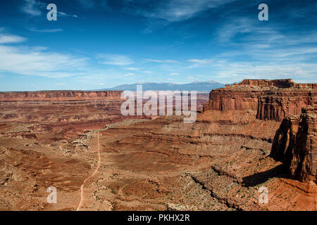 Blick von der Shafer Canyon Overlook in Richtung La Sal Mountains, Canyonlands National Park, Utah, USA. Stockfoto