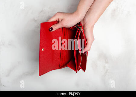 Weibliche Hände halten einen leeren stilvolle Geldbörse Rot auf weißem Granit Textur Stockfoto