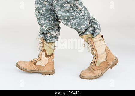 Teilansicht der männlichen Soldaten in der Tarnung Bekleidung und Stiefel auf grauem Hintergrund Stockfoto