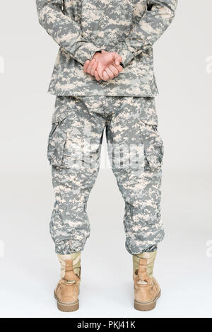 7/8 Schuß von Soldaten in Uniform und Stiefel isoliert auf Grau Stockfoto