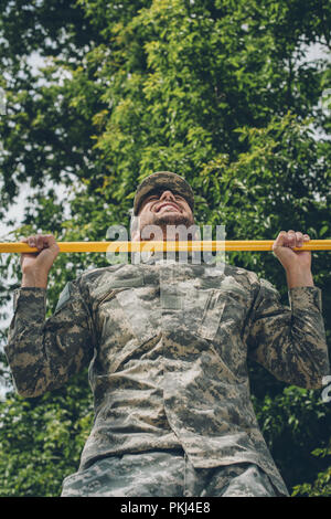 Low Angle View von Soldaten in Uniform sich Ziehen an der Querstrebe Stockfoto