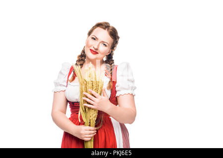 Lächelnd oktoberfest Kellnerin im traditionellen bayerischen Kleid holding Weizenähren isoliert auf weißem Hintergrund Stockfoto