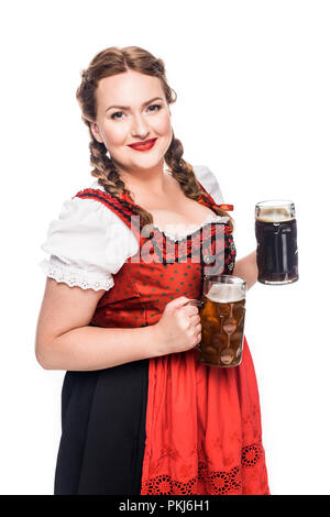 Happy oktoberfest Kellnerin im traditionellen bayerischen Kleid holding Becher mit hellen und dunklen Bier auf weißem Hintergrund Stockfoto