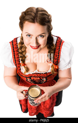 Hohe Betrachtungswinkel von lächelnden oktoberfest Kellnerin im traditionellen bayerischen Kleid holding Becher dunkles Bier auf weißem Hintergrund Stockfoto