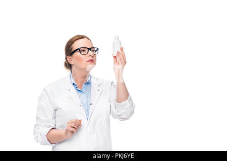 Ärztin in Brillen bei Pille Flasche suchen auf weißem Hintergrund Stockfoto