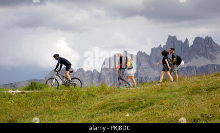 Cortina d'Ampezzo, Italien - 18 August, 2018: einige Wanderer und Radfahrer auf dem Berg Trail, an einem bewölkten Sommertag. Im Hintergrund der Gipfel des t Stockfoto