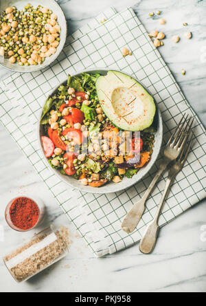 Vegan Schüssel mit Avocado, Getreide, Bohnen und Gemüse mit Besteck Stockfoto