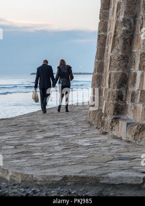 Larnaca, Zypern - 01 Januar 2018: Junge unbekannte Paar Hand in Hand gehen mit in der Nähe der Burg in Larnaca auf Zypern Stockfoto