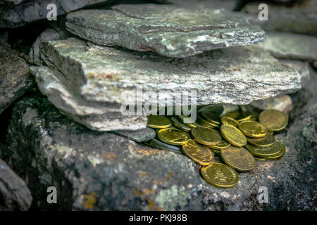 Geworfen goldenen Münzen zwischen den Felsen für Glück. Menschen machen Wünsche und symbolisch das Geld für Glück werfen. Stockfoto