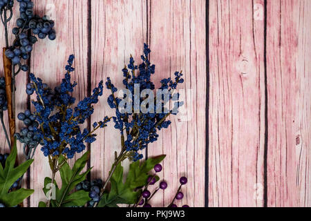 Hübsche blaue Blumen und Heidelbeeren auf einem rosa Hintergrund aus Holz. Viel Platz kopieren Stockfoto