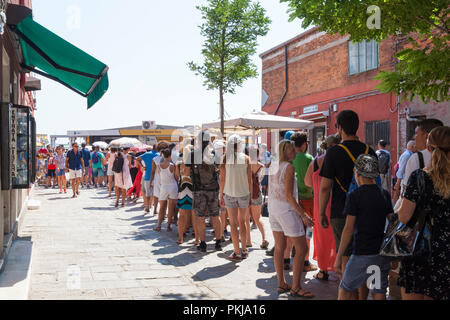 Touristen Queuing auf der Insel Murano, Venedig, Venetien, Italien in der Calle Bresaggio der Vaporetto nach Burano zu fangen. Lange Schlange von Menschen, Queue, Menge, Stockfoto