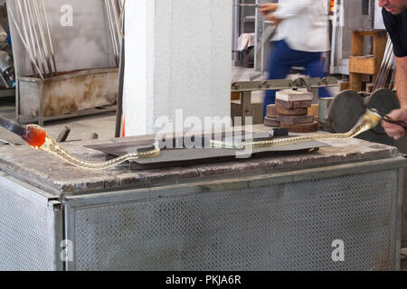 Glasbläser produziert ein Kronleuchter in Simone Cenedese Fornace, Ofen, Murano, Venedig, Venedig, Italien biegen das geschmolzene Glas den Arm zu bilden Stockfoto