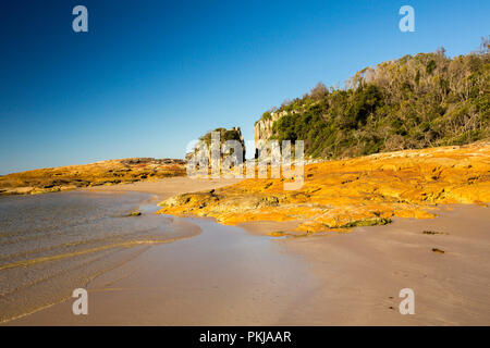 Australische Küstenlandschaft mit einsamen Sandstrand und Felsen unter blauen Himmel bei Diamond Head in Überfüllt Bay National Park NSW Stockfoto