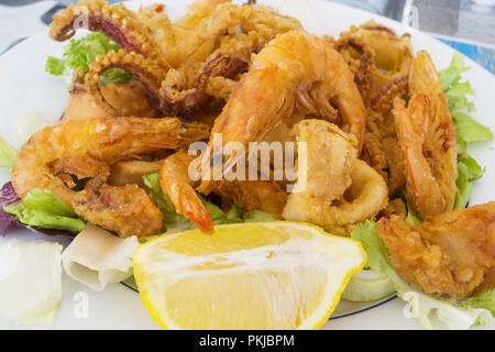 Gebratene Garnelen mit einer Scheibe Zitrone und grünem Salat Stockfoto