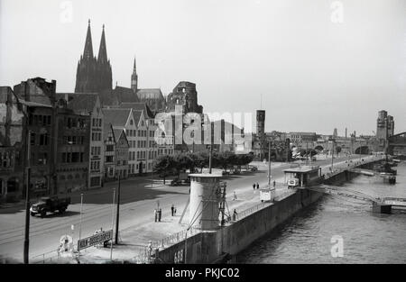 1950 s, historischen, einen Blick über die Altstadt von Köln, beisde den Rhein, zeigt die Türme der berühmten gotischen Kathedrale der Stadt. Die katholische Kirche wurde im Zweiten Weltkrieg beschädigt, aber nicht zerstört. Stockfoto