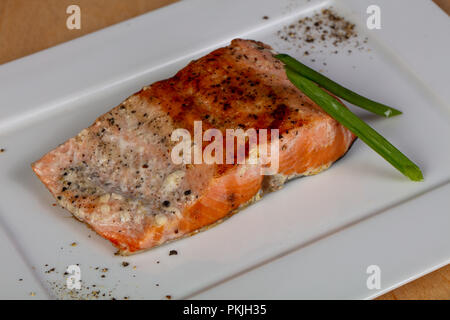 Gebratenes Lachssteak serviert grüne Zwiebel Stockfoto