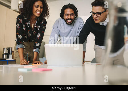 Creative Business Leute, die an einem Notebook arbeitet und das Diskutieren von Ideen im Büro. Unternehmer weitergeben von Ideen und Pläne mit Kollegen im Büro auf Stockfoto