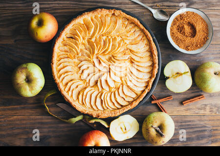 Frisch gebackenen Apfelkuchen Kuchen mit Pudding Auffüllen auf einem rustikalen Holztisch. Ansicht von oben Stockfoto