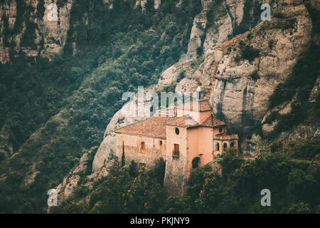 Montserrat, Katalonien, Spanien. Blick von oben auf die Hügel Höhle Santa Cova de Montserrat oder Heilige Höhle von Montserrat im Sommer Tag. Santa Maria de Montserrat EIN Stockfoto