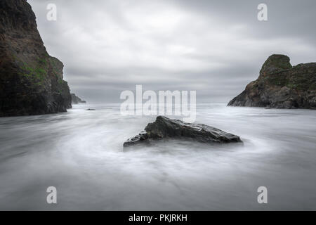 Wellen um Rock, Whipsiderry Strand, Porth, Newquay, Cornwall Stockfoto