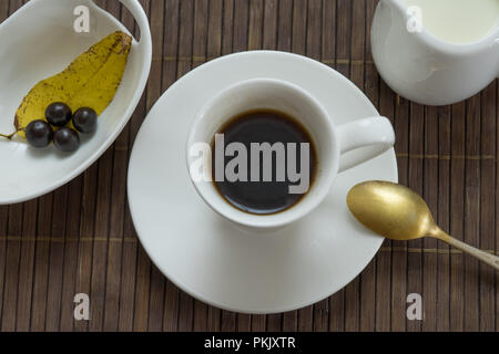 Stillleben mit schwarzen Kaffee auf einem dunklen Hintergrund mit Herbst gelbe Blätter Stockfoto