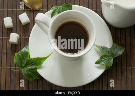 Stillleben mit schwarzen Kaffee auf einem dunklen Hintergrund mit Herbst gelbe Blätter Stockfoto