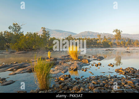 Atemberaubende australische Landschaft mit Felsen verstreut blaue Wasser von Mann Fluss gesäumt von Wäldern am Fuße der Bereiche unter blauem Himmel des frühen Morgens in NSW
