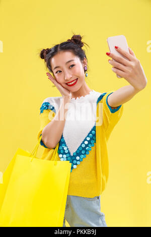Junge Frauen nehmen auf Handys Stockfoto