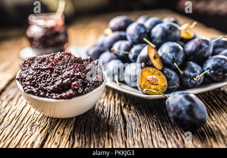 Close-up Löffel aus Pflaumenmus und frischen Pflaumen im Hintergrund. Stockfoto