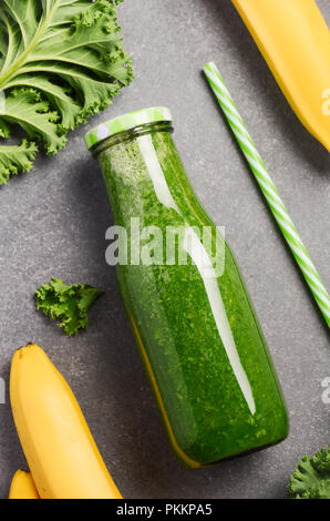 Frische grüne Smoothie mit Grünkohl und Banane in einer Flasche, Ansicht von oben. Stockfoto