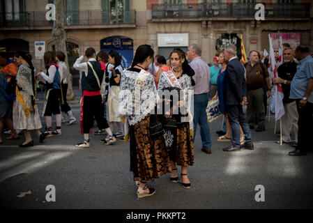 Junge Frauen in der katalanischen traditionellen Kostümen während la Iada in den Straßen von Barcelona gekleidet. Katalanen feiern La Iada oder in Katalonien Nationalfeiertag in einer Atmosphäre der Konflikt mit der spanischen Regierung für den Inhaftierten städtischer Abgeordneter Führer und Proklamationen für die Unabhängigkeit. Stockfoto