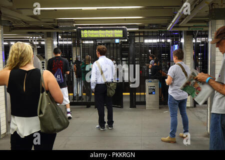 Personen, die außerhalb einer NYC U-Bahn Fahrpreis Tor überlegen, ob das System während einer Abfahrt board große Verzögerungen im System entspricht. Stockfoto