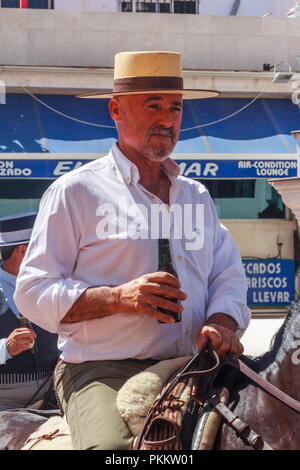 Arroyo de la Miel, Spanien - 17. Juni 2018: der Mann, der auf dem Rücken der Pferde trinken Bier an einem lokalen Fiesta. Spanien ist bekannt für seine Feste. Stockfoto