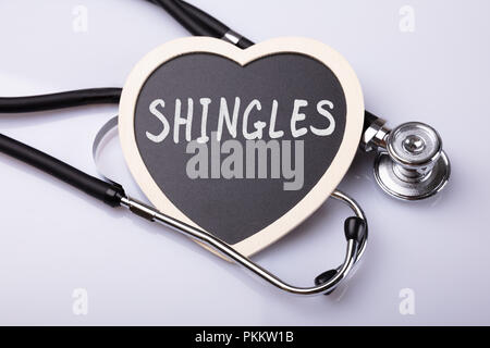 Stethoskop und Herz mit dem Wort Cholesterin auf weiße Oberfläche Stockfoto
