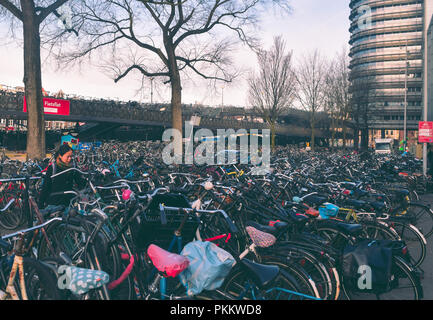 Frau ihr Fahrrad im Parkplatz des Bahnhof Stockfoto