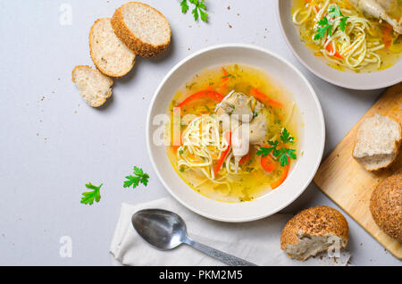 Wachtel Nudelsuppe, hausgemachte Brühe mit Nudeln und Gemüse serviert mit Brot, Brötchen, Komfort Essen Stockfoto
