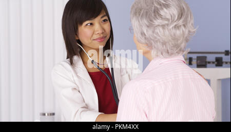 Chinesische Arzt hören auf das Herz des älteren Patienten Stockfoto