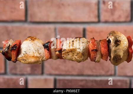 Gegrillte Spieße mit Gemüse und Fleisch im Hintergrund eine Wand. Peruanische. Stockfoto