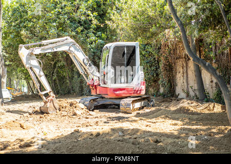 Bagger arbeiten am Boden für den Bereich neben Bäume für neue Park Gebäude Stockfoto