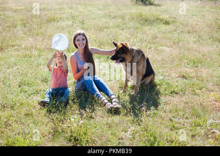 Mutter und Sohn spielen mit Hund Schäferhund Ausbildung Stockfoto
