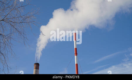 Kesselraum in der Wintersaison, aus den Schornsteinen aufstieg bis Wolken von Dampf. Rohre mit einem Blockheizkraftwerk. Kesselhaus, Rohr, Kesselanlage. Stockfoto