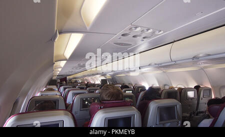 Kabine mit Sitzreihen. Innenraum Passagiere Flugzeug mit Personen auf Sitzplätzen. Passagiere, die von einem modernen kommerziellen Ebene. Travel Concept. Stockfoto