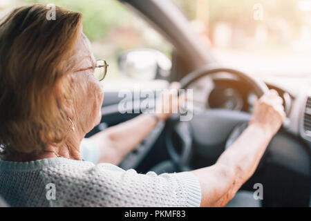 Ältere Frau hinter dem Lenkrad eines Autos Stockfoto