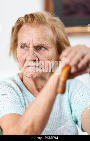 Ältere Frau in den 80ern mit einem Spazierstock Stockfoto